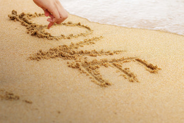 Hand drawing love on sand.
