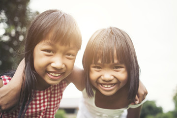 Two little girls friends playing funny in the park