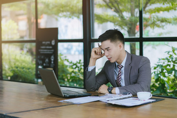 Fototapeta premium Portrait of young man sitting at his desk in the cafe. Businessmen stress.