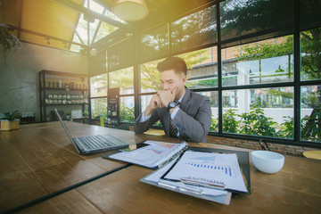 Portrait of young man sitting at his desk in the cafe. Businessmen stress.