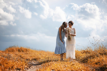 Two girls in dresses in autumn field