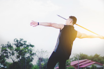 sportsman warming up and practicing javelin throw in yard