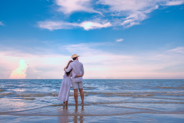 Happy young couple holding each other and laughing with enjoying together on the summer beach,...