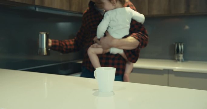 Father in kitchen with toddler pouring coffee