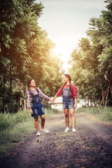 Fototapeta premium Two girls walking along a forest road