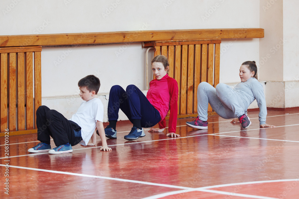 Wall mural Primary school children a sport lesson indoors