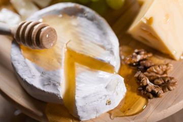 Cheese plate, honey pouring on camembert cheese