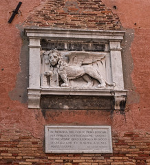 Stone bas-relief of the Venetian lion on the wall of the Arsenal of Venice. The lion of St. Mark is a symbol of the city of Venice, and one of the elements of the flag of the Italian fleet.
