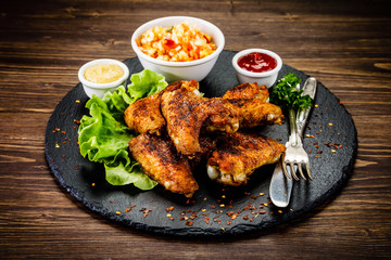 Chicken wings with French fries on wooden background 