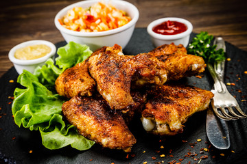 Chicken wings with French fries on wooden background 