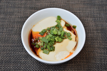 Tofu with  soya sauce on white bowl