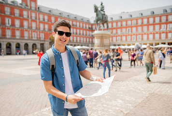 good looking young man traveler holding up a map in madrid