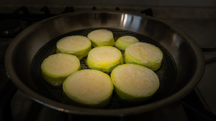 Green Courgettes fry in a skillet in olive oil