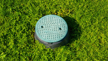 Water hatch on a green lawn