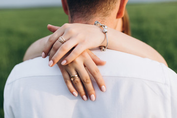 The lovely couple in love embracing and standing on the field