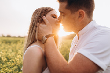 The husband kissing his wife and standing on the field