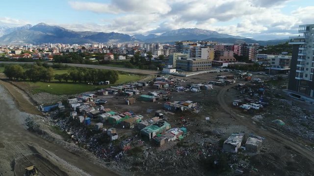 Aerial view of 'slums' of temporary Roma minority camp, contrast with modern Shkoder city in Albania