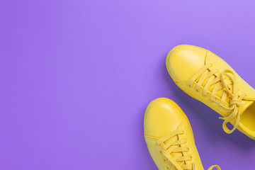Pair of yellow shoes on violet background. Trendy summer color.