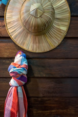 Weave hat and loincloth Thai style with the old wooden table background.