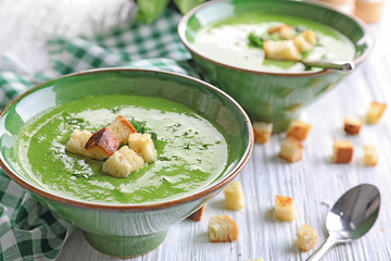 Bowl with delicious spinach soup on table