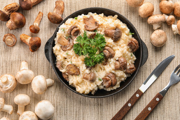 Composition with risotto and mushrooms on table, top view