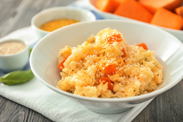 Bowl with delicious pumpkin risotto on wooden table