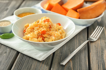 Bowl with delicious pumpkin risotto on wooden table