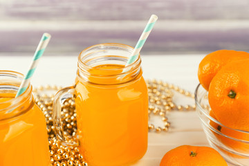 Mason jars with fresh citrus juice on table