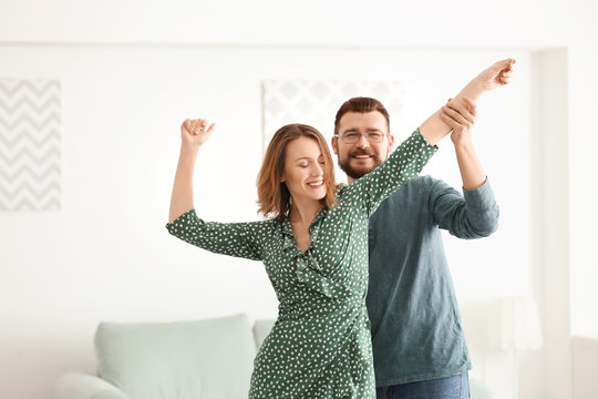 Lovely couple dancing together at home