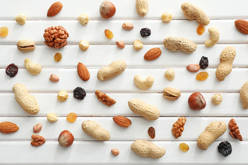 Various tasty nuts and dried fruits on wooden background