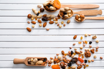 Various tasty nuts and dried fruits on wooden background