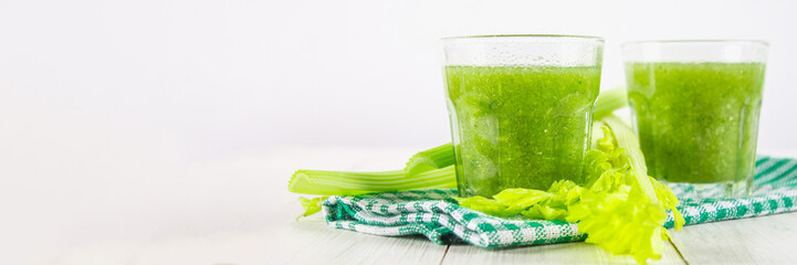 Vegetable cocktail made from celery leaves, healthy lifestyle on a white wooden background.