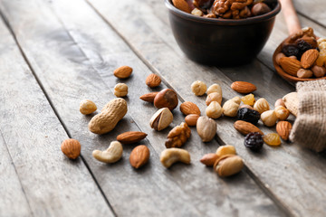Various tasty nuts and dried fruits on wooden table