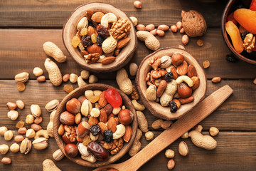 Bowls with various tasty nuts on wooden table