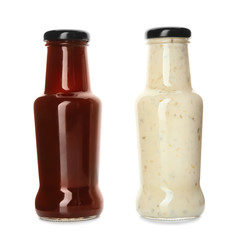 Bottles with tasty sauces on white background