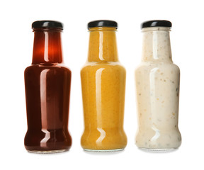 Bottles with tasty sauces on white background
