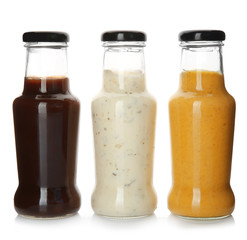 Bottles with tasty sauces on white background