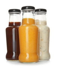 Bottles with tasty sauces on white background