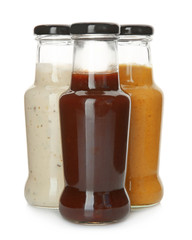 Bottles with tasty sauces on white background