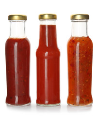 Bottles with tasty sauces on white background