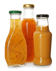 Bottles with tasty sauces on white background