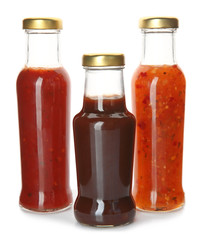 Bottles with tasty sauces on white background
