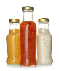 Bottles with tasty sauces on white background