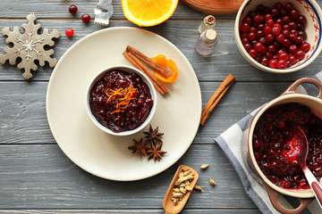 Flat lay composition with cranberry sauce and ingredients on wooden background