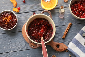Flat lay composition with cranberry sauce and ingredients on wooden background