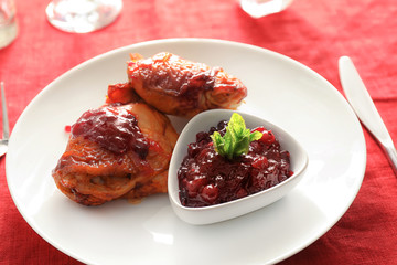 Fried chicken served with cranberry sauce on plate
