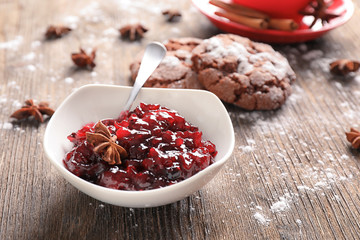 Bowl with tasty cranberry sauce on table