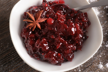 Bowl with tasty cranberry sauce on table, top view
