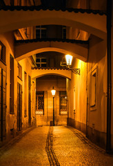 Beautiful old street with arches in Prague, Czech Republic shoot at night with the old retro lamp glowing afar