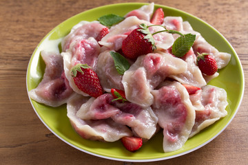 Dumplings, filled with strawberries. Pierogi, varenyky, vareniki, pyrohy - dumplings with filling, popular dish in many countries